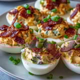 Cream cheese-stuffed jalapeño deviled eggs with smoky bacon and tangy cheddar for a bold appetizer twist.