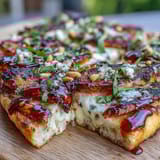 Sweet grilled peaches and creamy Brie cheese melt over smoky BBQ flatbread, garnished with herbs.  