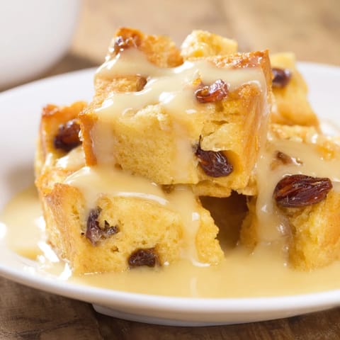 This delicious bread pudding shows baked, custardy bread with plump raisins and cinnamon aromas for enjoyment.