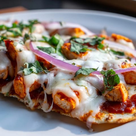 Homemade BBQ chicken flatbread with sweet red onions and fresh cilantro, served warm as a main dish.  