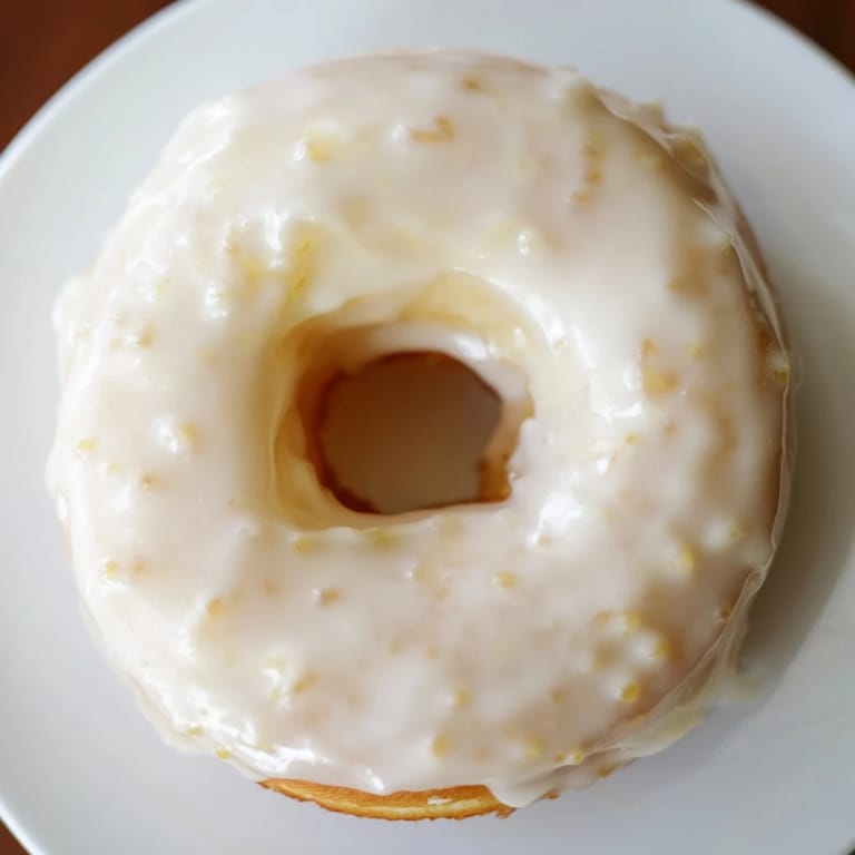 Close-up of freshly glazed Glazed Yeast Donuts with a smooth, glossy vanilla glaze, a perfect dessert.