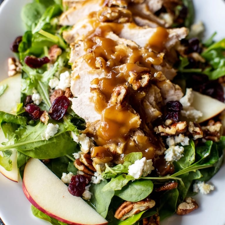 Golden caramel-pecan dressing drizzled over a colorful autumn salad with crumbled feta and dried cranberries for sweet contrast.  