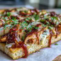 Crispy BBQ chicken flatbread pizza with smoky sauce, melty cheese, and colorful bell peppers.  